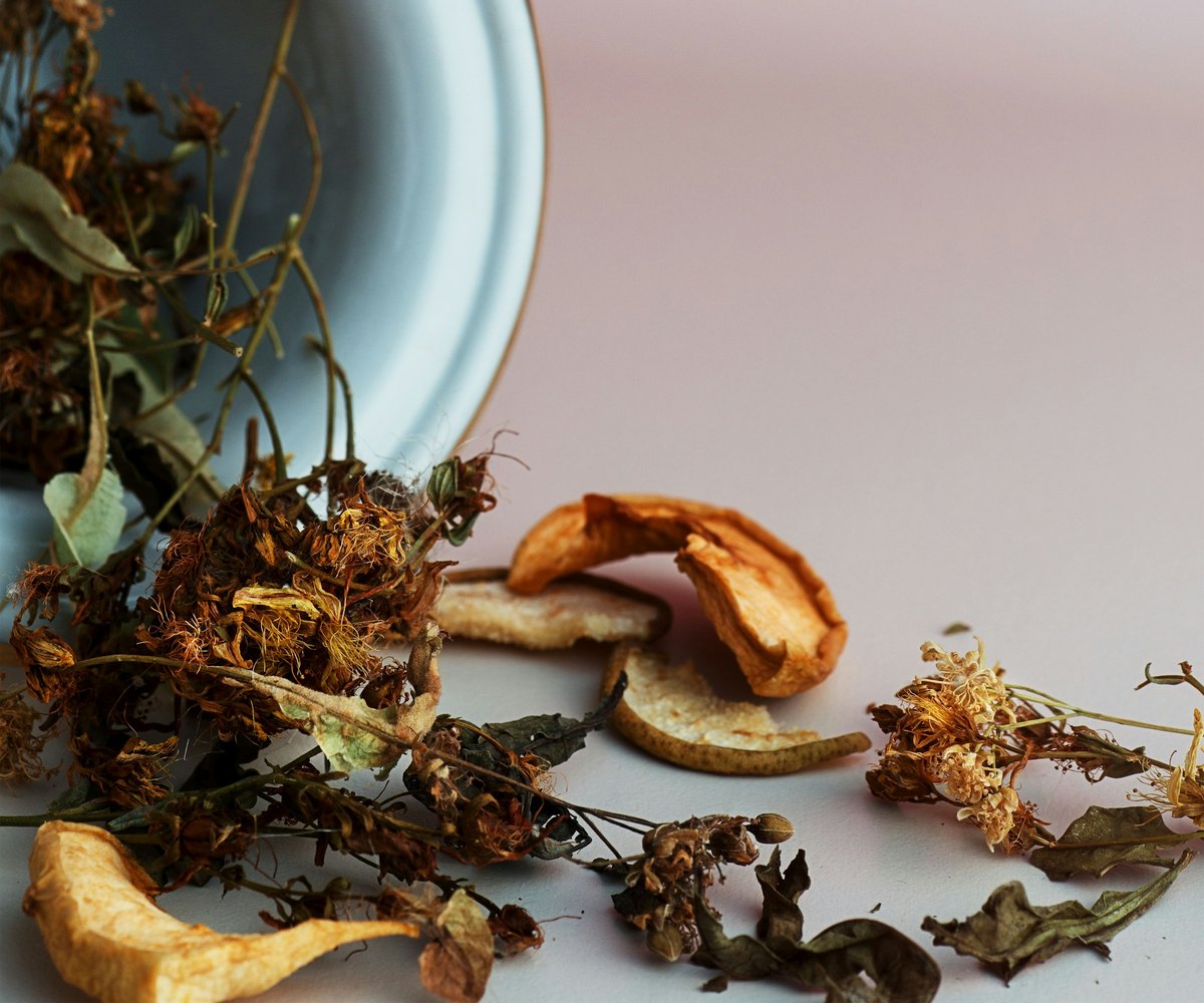 Getrocknete Kräuter, Blüten und Fruchtscheiben in einer Schale